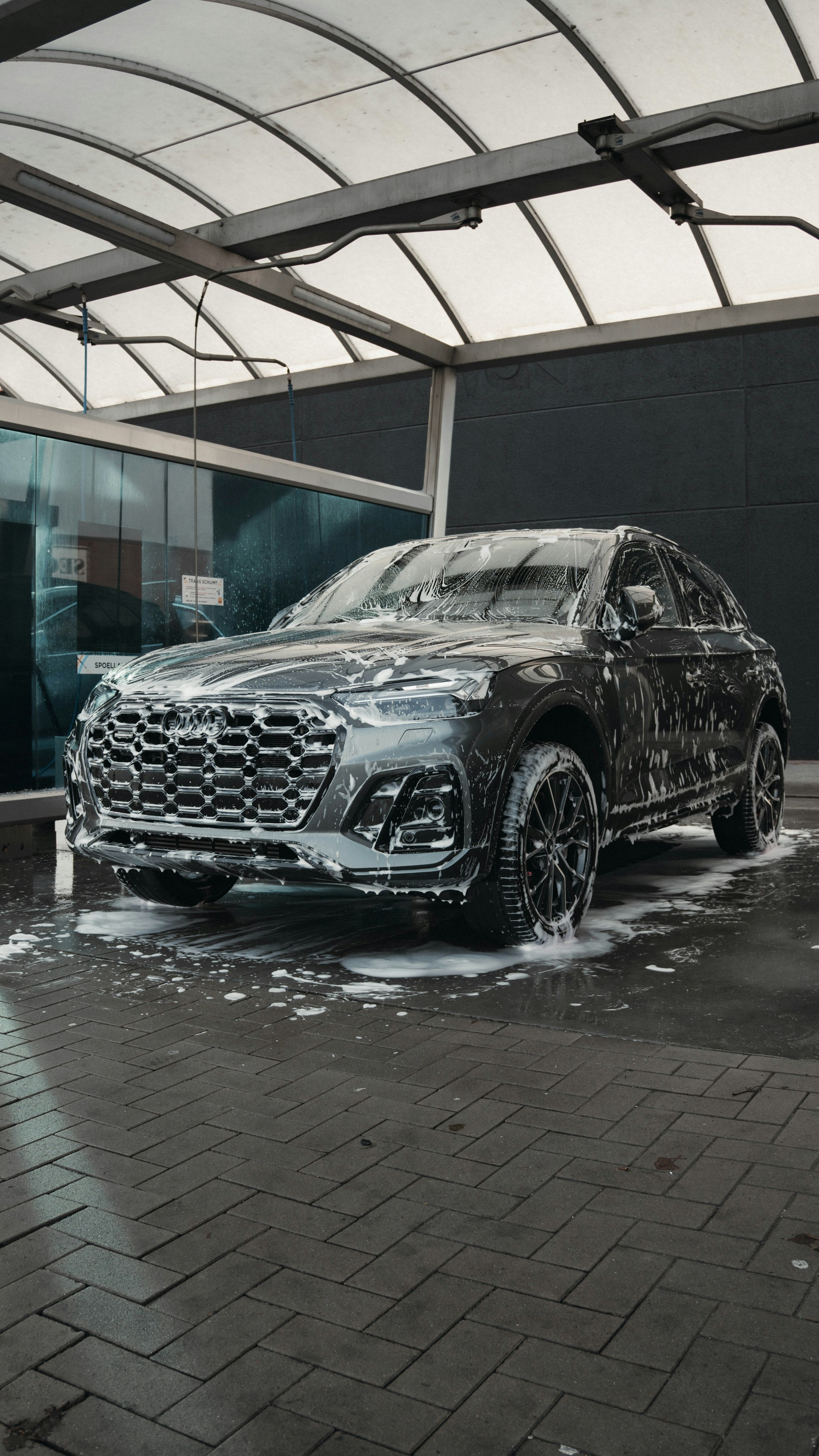 Professional foam wash on a dark SUV